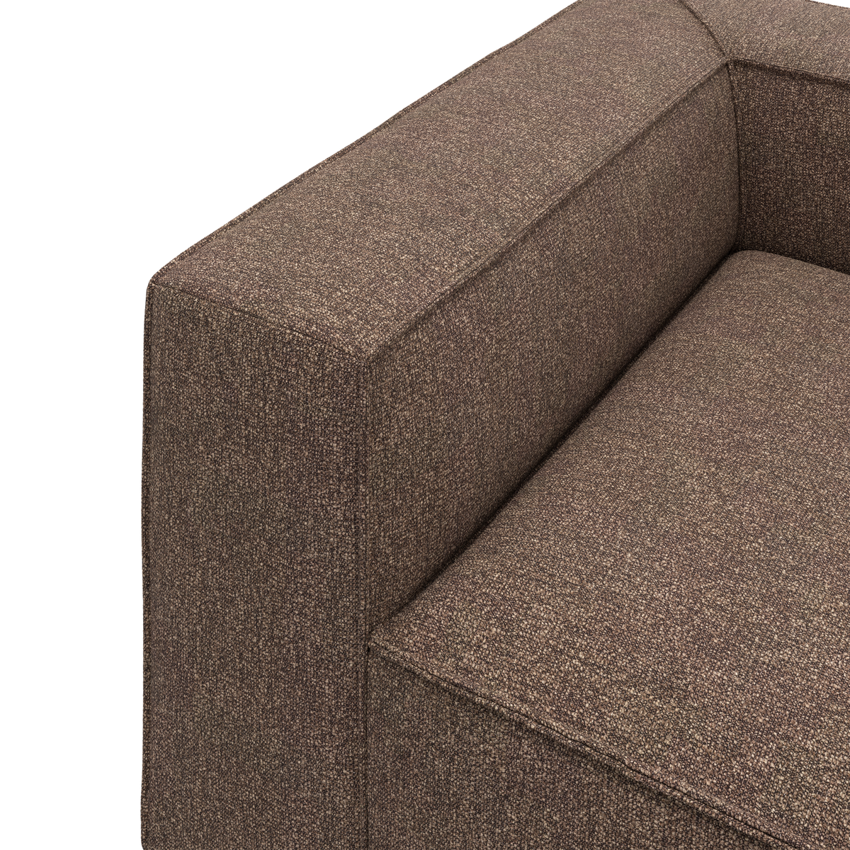 Nærbillede af brun stofsofa med bred armlæn og sæde.