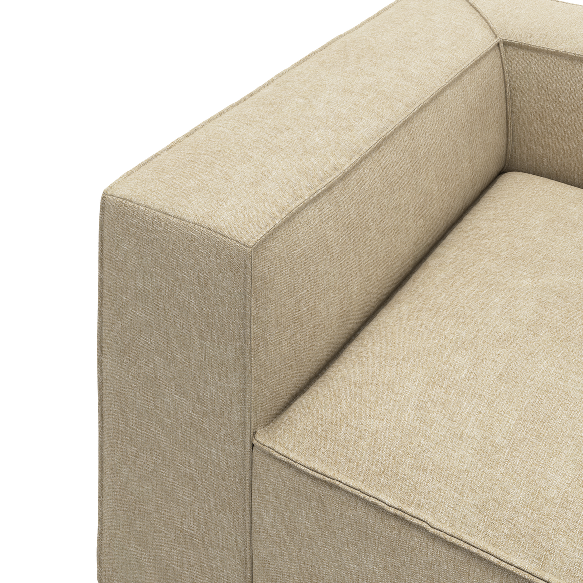 Beige stofsofa – close-up af armlæn og sæde med rene, kantede linjer.