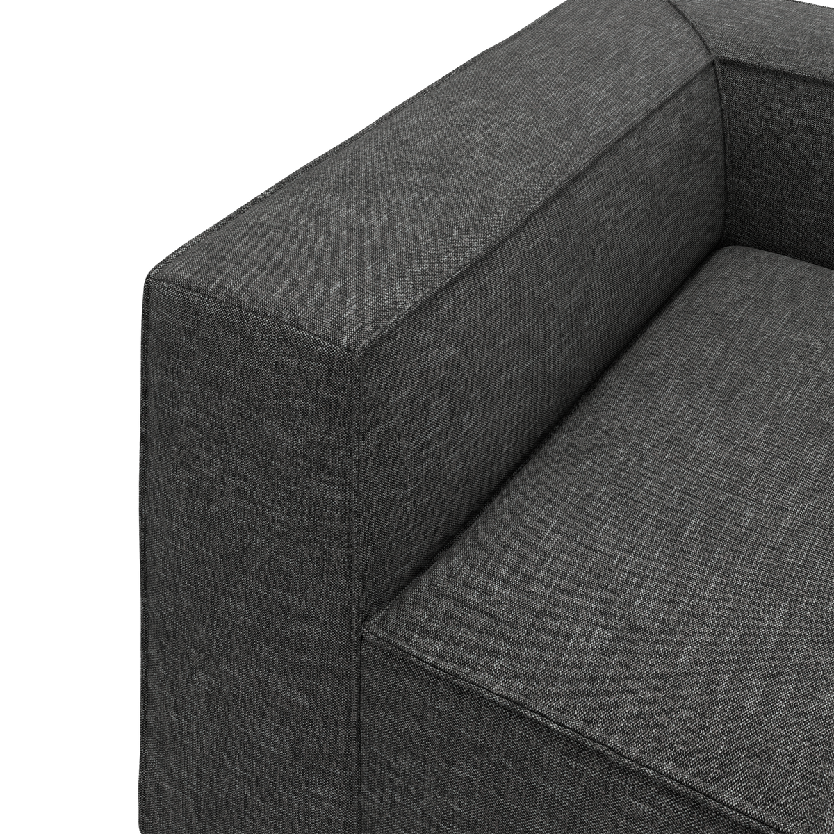 Nærbillede af mørkegrå stofsofa med bred armlæn og sæde i stramt, moderne design.