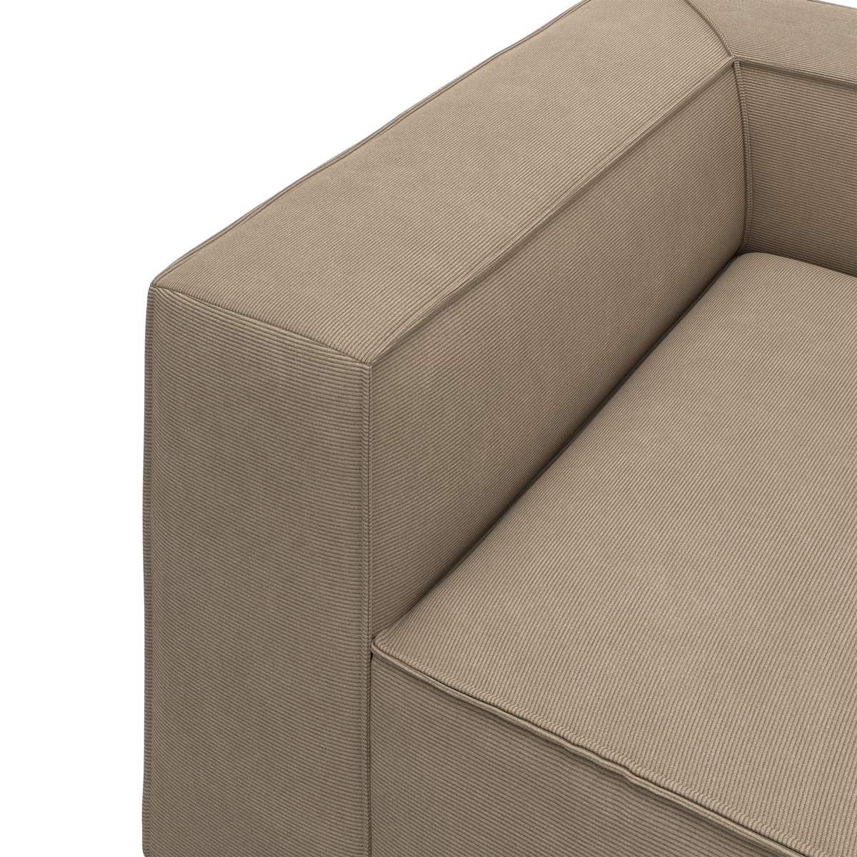 Nærbillede af beige sofa med bredt, kantet armlæn og sæde i finriflet tekstil.