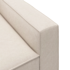 Detaljebillede af beige sofa med lige armlæn og sædepude.
