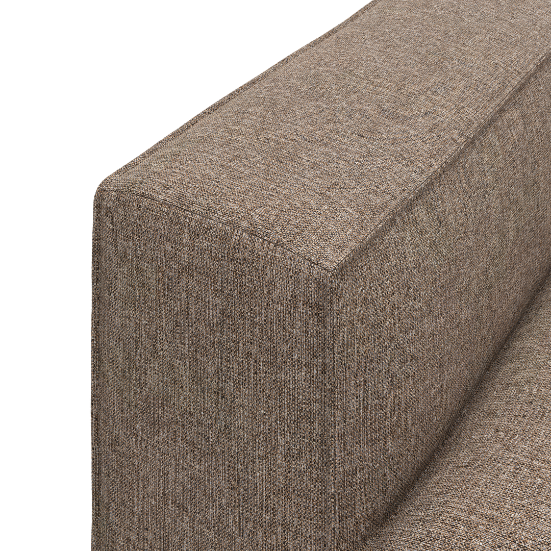 Nærbillede af brunmeleret stofsofa – lige, bokset armlæn i moderne design.