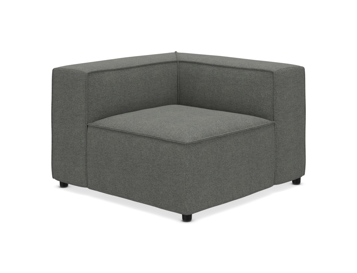 Grå polstret hjørnemodul til sofa i stof, moderne design med lavt ryglæn på hvid baggrund.