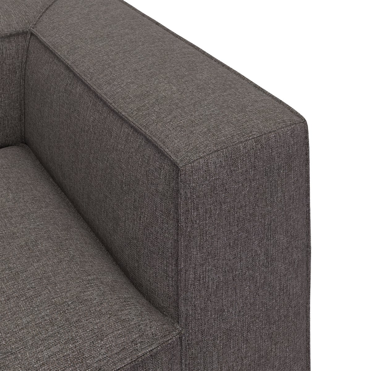Nærbillede af en grå stofsofas armlæn med skarpe, boxy linjer.