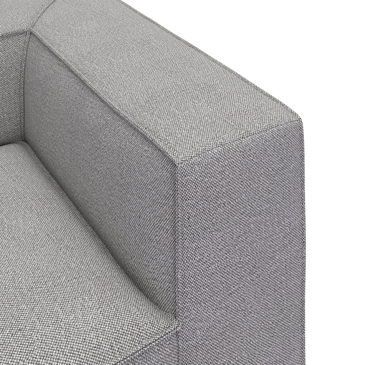 Nærbillede af en grå stofsofas armlæn og sæde i studie, minimalistisk design.