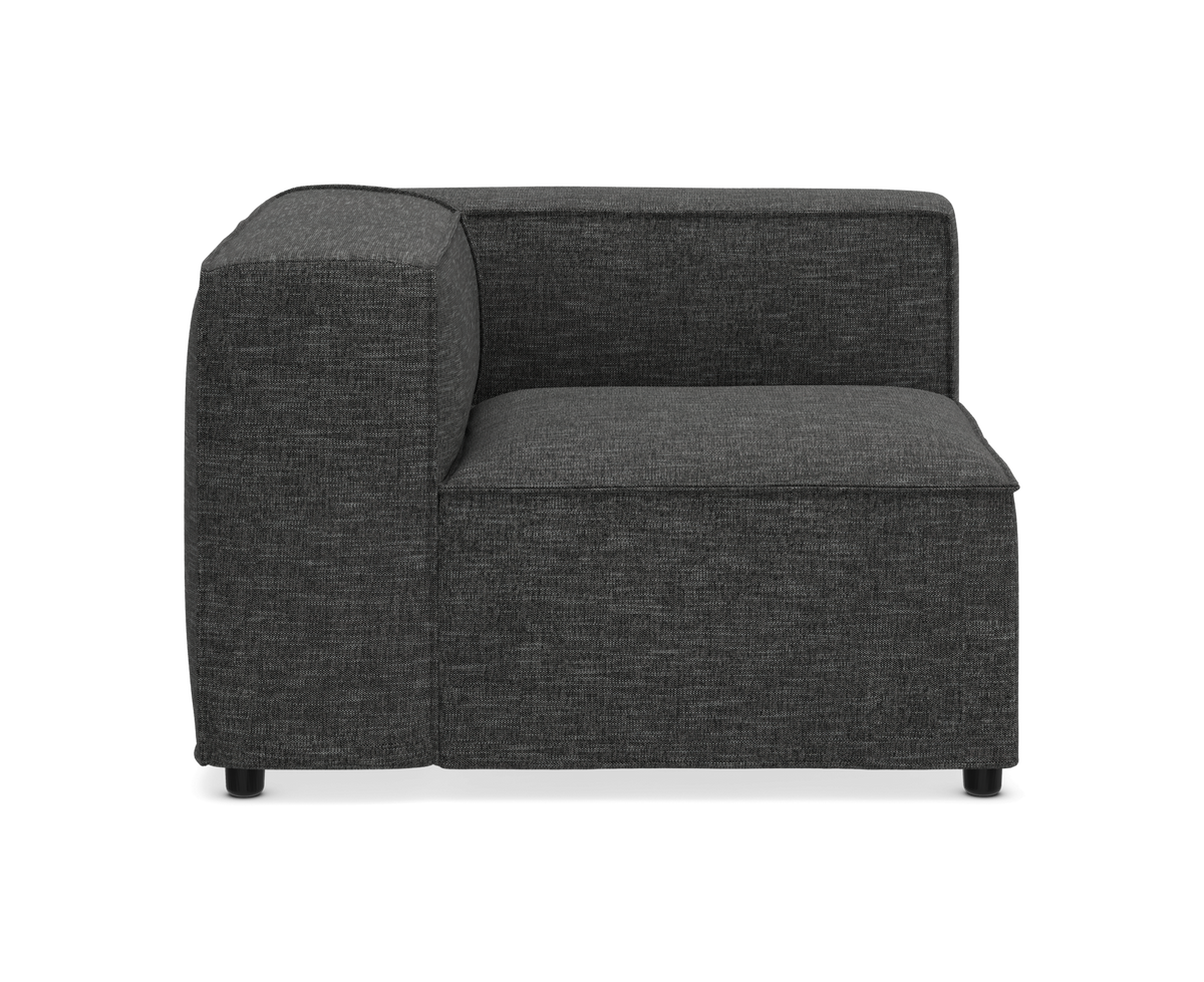 Mørkegrå modulsofa, hjørnemodul i stof med lav ryg, fritlagt mod hvid baggrund.