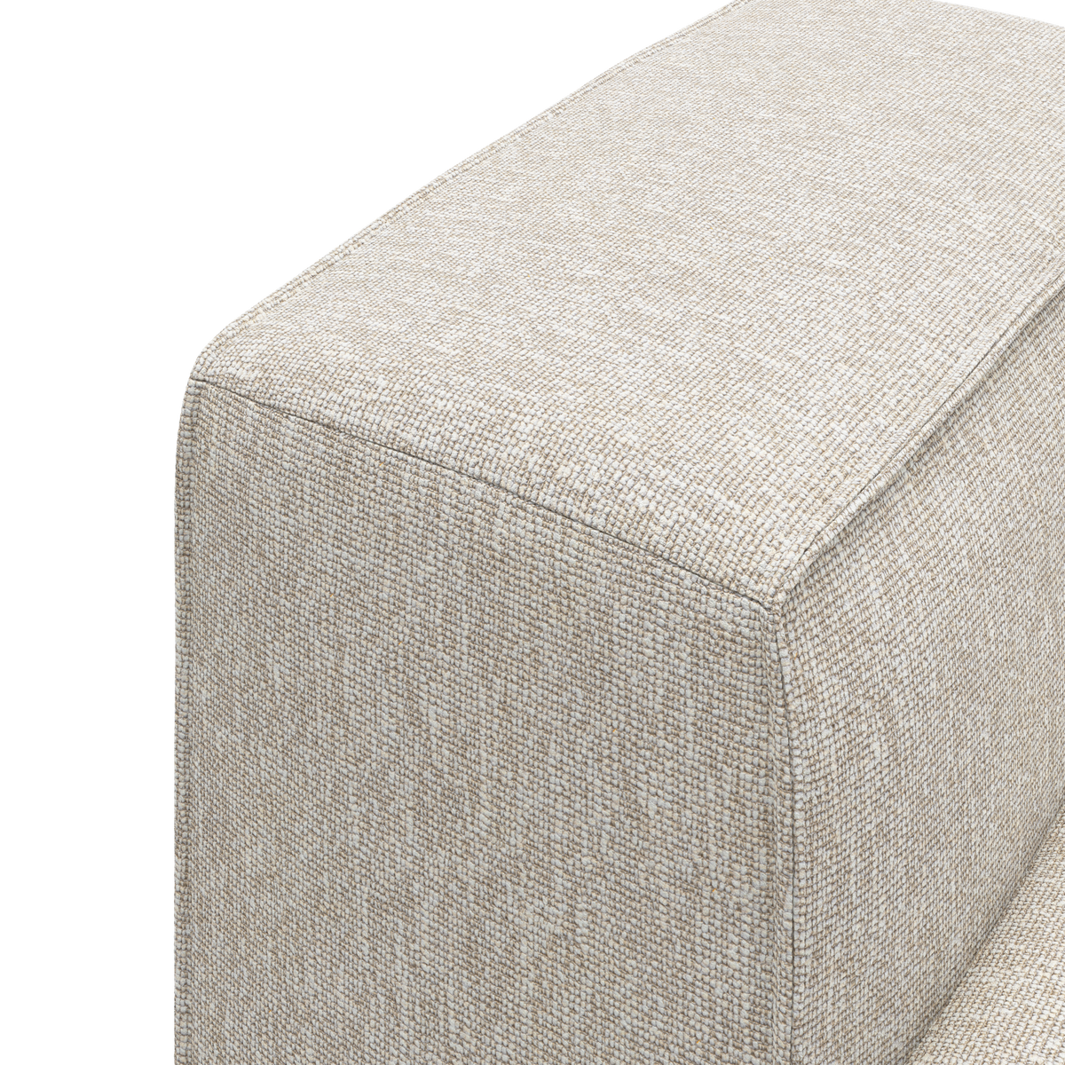 Beige stofbeklædt sofamodul—nærbillede af hjørne med synlige syninger på hvid baggrund.