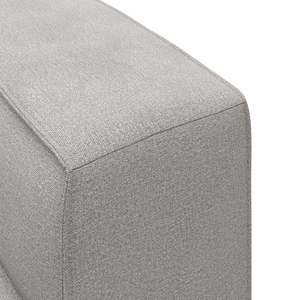Nærbillede af hjørnet på en grå stofbetrukket sofa/ottoman på hvid baggrund.