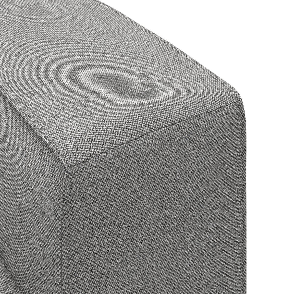 Nærbillede af et gråt, struktureret tekstil på et rektangulært sofa-/pufhjørne i studielys.