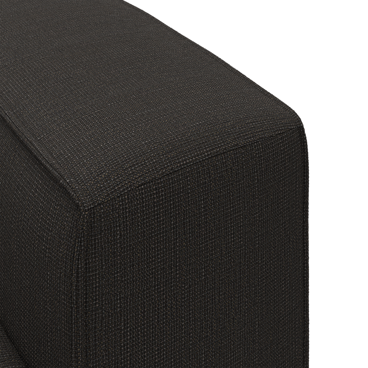 Nærbillede af mørk, tekstureret stofpolstring på et møbelhjørne, sandsynligvis sofa eller puff.