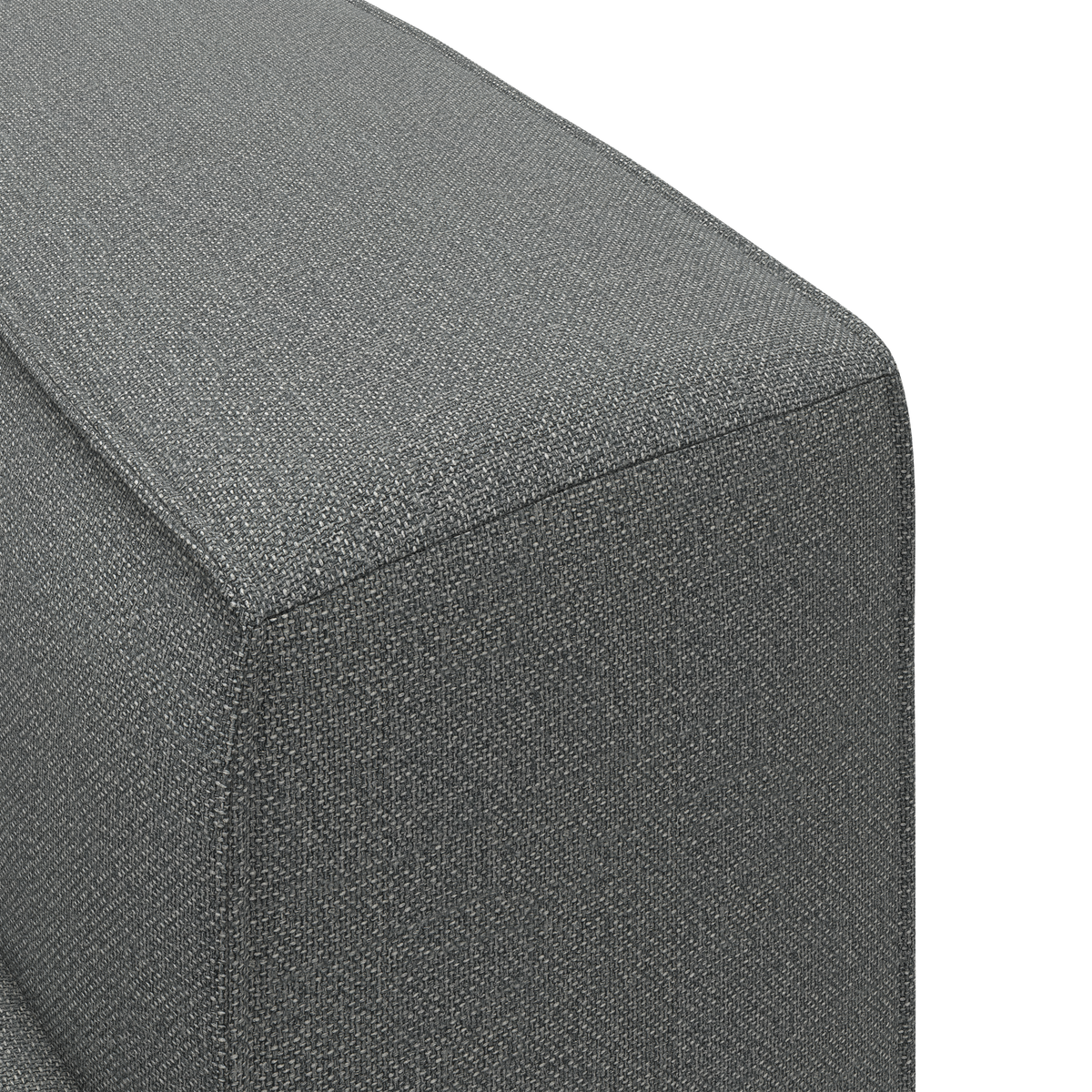 Nærbillede af et gråt stofbetrukket sofa-hjørne/arm i en ren studiemiljø.