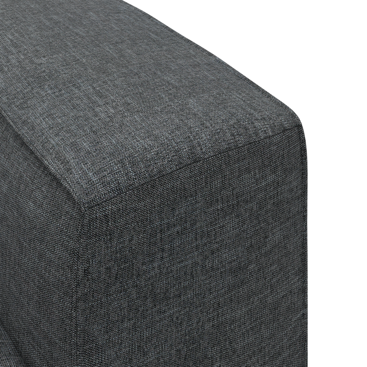 Nærbillede af et mørkegråt stofbetrukket hjørne af en sofa eller puf i enkel, ren design.