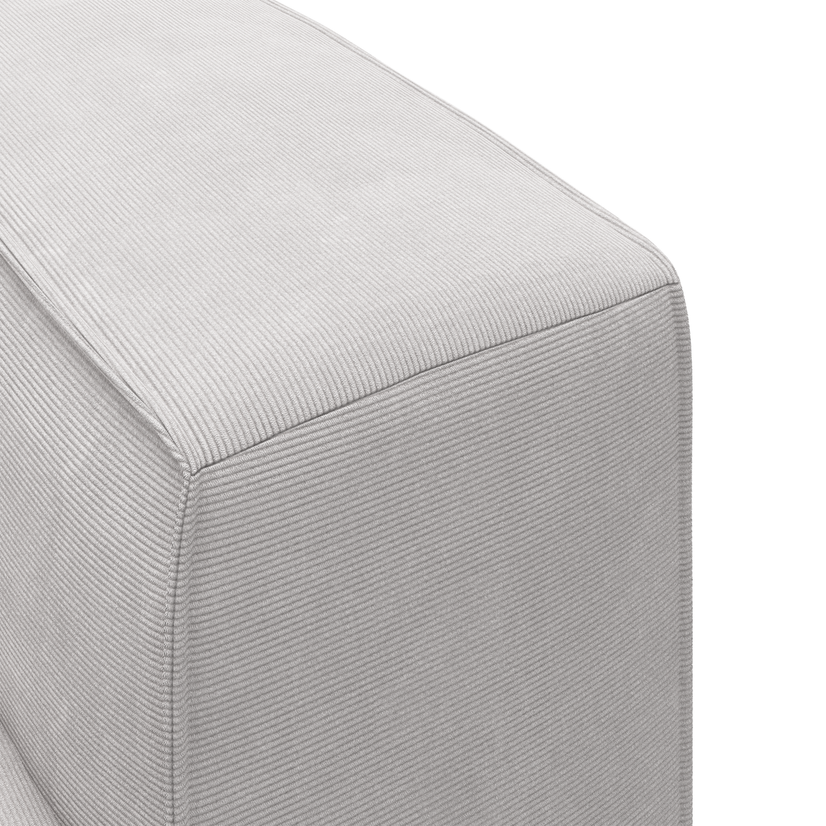 Nærbillede af hjørnet på en lysegrå puf/sofa i fløjl/corduroy, frilagt mod hvid baggrund.