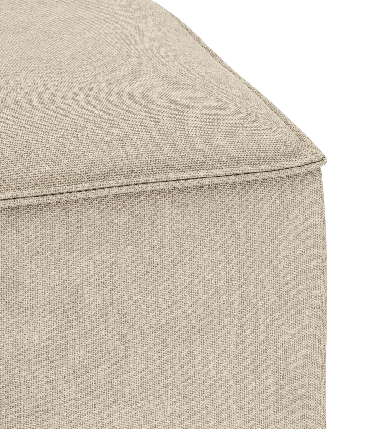 Nærbillede af hjørne på beige stofbetrukket puff/ottoman med synlig piping.