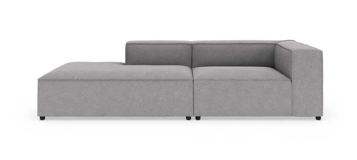 Grå modulsofa med venstrevendt chaiselong, fotograferet lige for mod hvid baggrund.