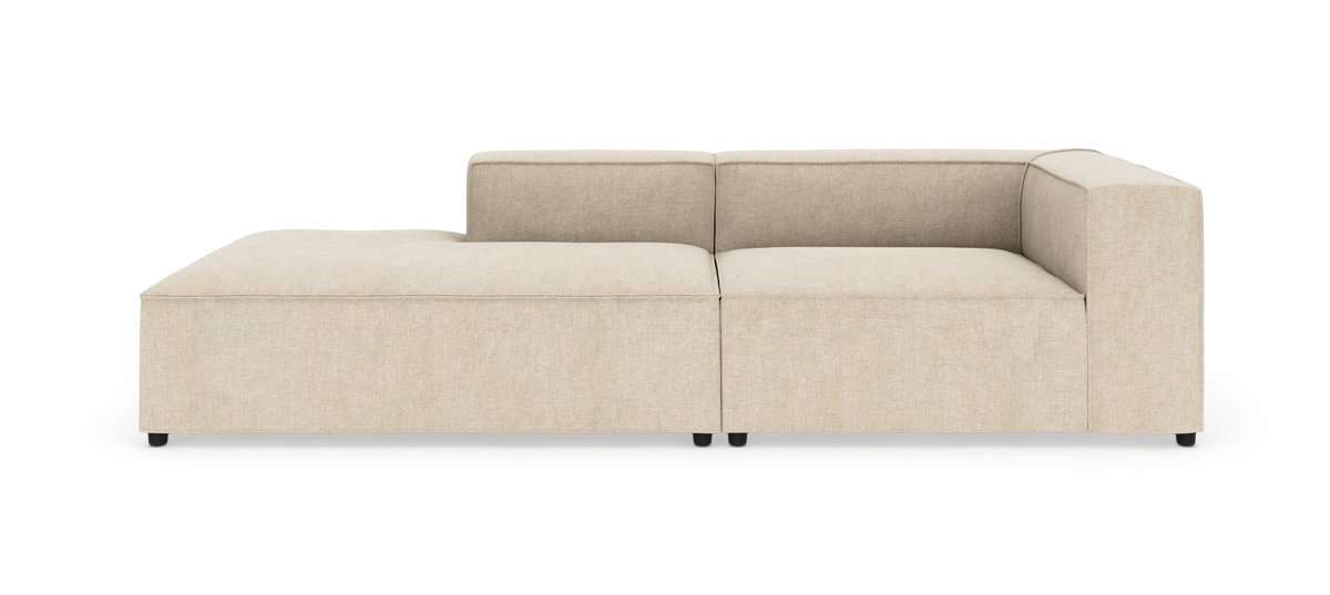 Beige modulsofa med chaiselong til venstre og armlæn/ryg til højre, frilagt på hvid baggrund.