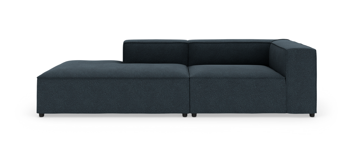 Mørkeblå modulsofa med højre armlæn og venstre chaiselong på hvid baggrund.
