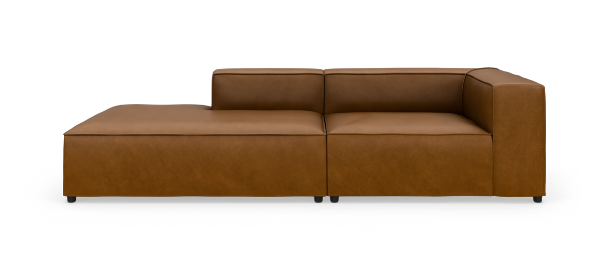 Brun lædersofa med venstrevendt chaiselong og højre armlæn, fotograferet lige for mod hvid studiebaggrund.