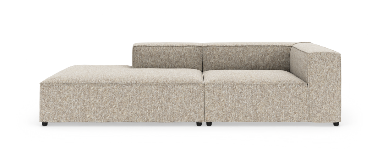 Lys beige modulsofa med venstrevendt chaiselong og kubiske armlæn, fritlagt på hvid baggrund.