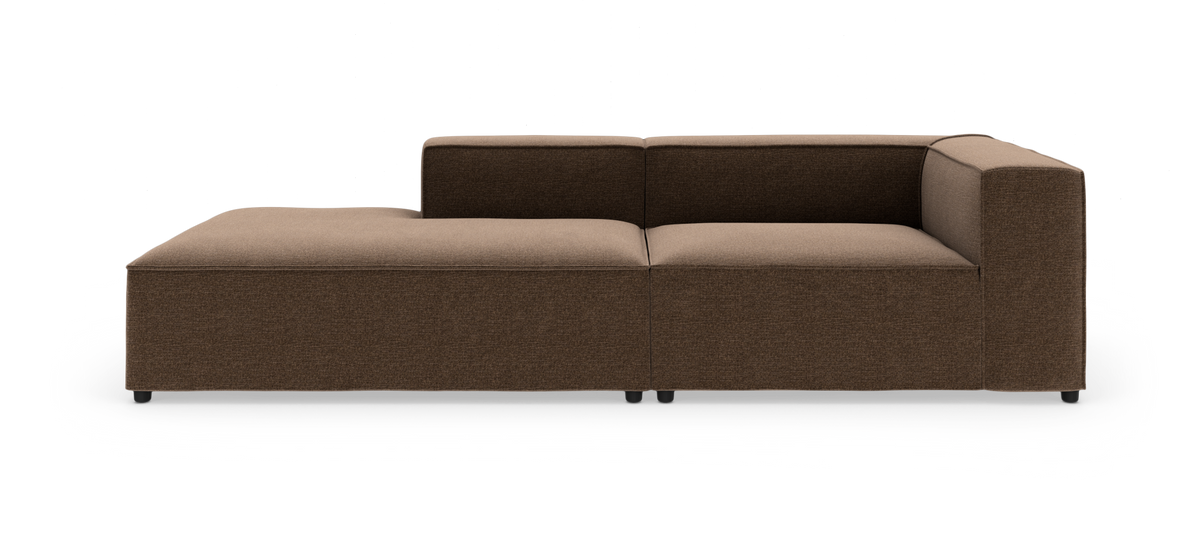 Modulsofa i brun tekstil med venstrevendt chaiselong, set lige for i studiemiljø.