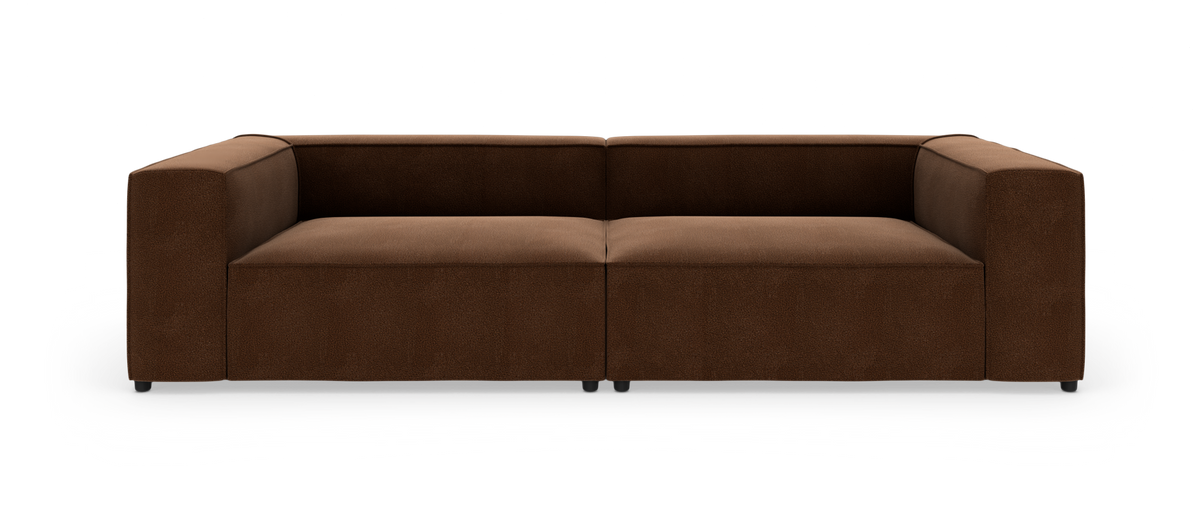 Brun modulsofa med brede armlæn, fotograferet lige forfra i studie på hvid baggrund.