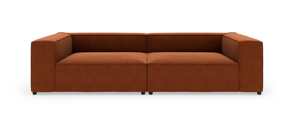 Rustrød, lav og bred 2-personers sofa med kraftige armlæn, frilagt på hvid baggrund.