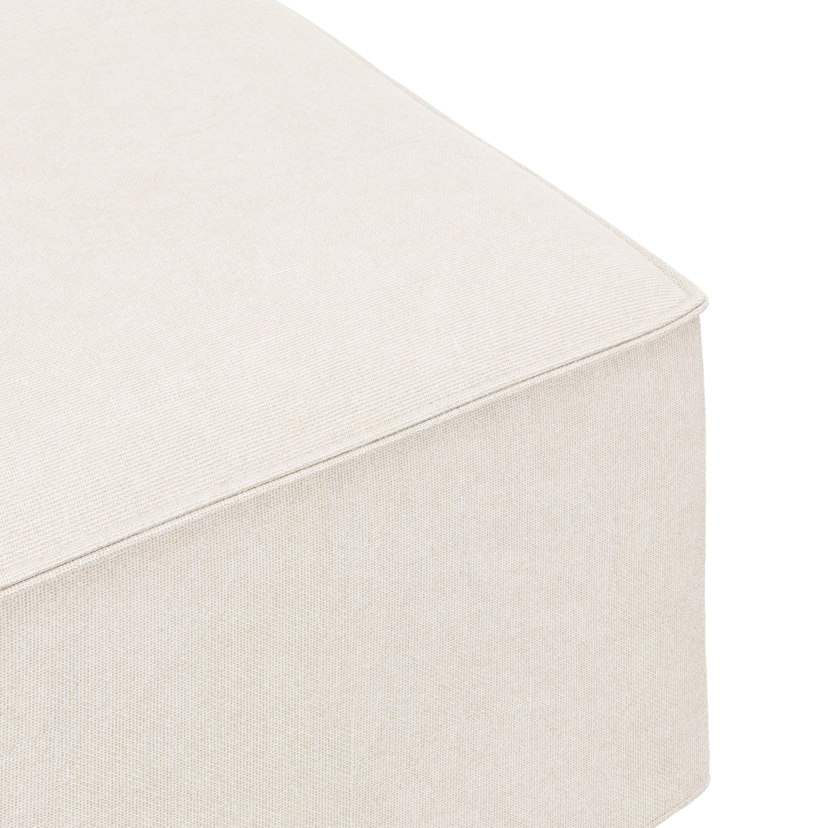 Nærbillede af beige stofbetrukket ottoman/modul set fra et hjørne mod hvid baggrund.