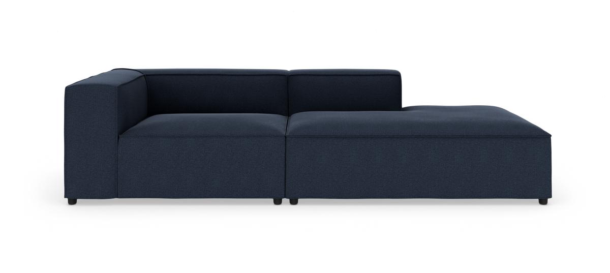 Mørkeblå modulsofa med chaiselong til højre på hvid baggrund, set lige forfra.