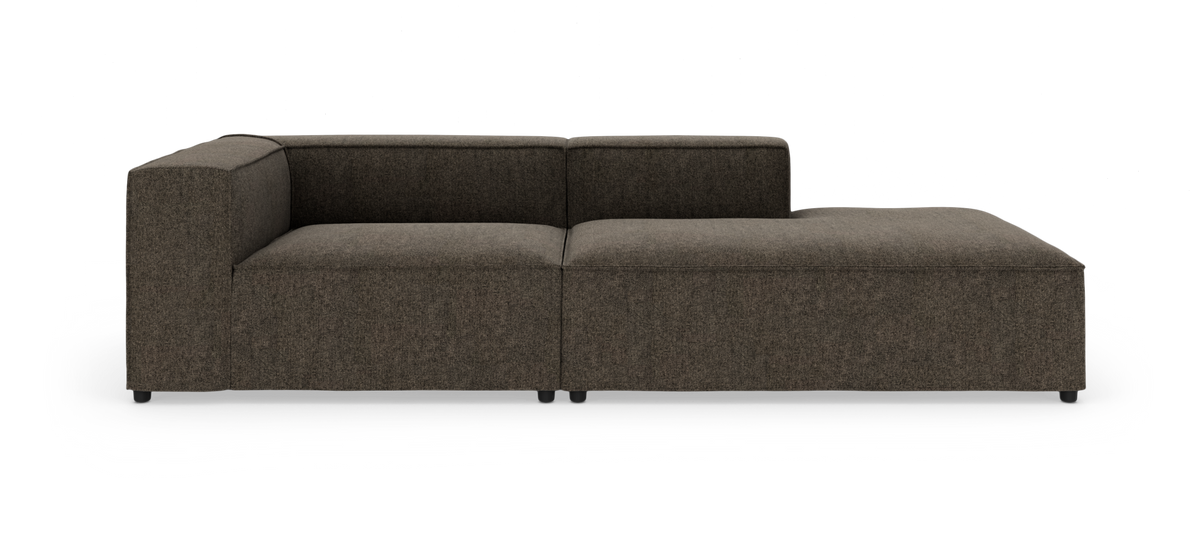 Modulær brun hjørnesofa/chaise longue i stof med lav ryg og blokformede armlæn, fritlagt på hvid baggrund.