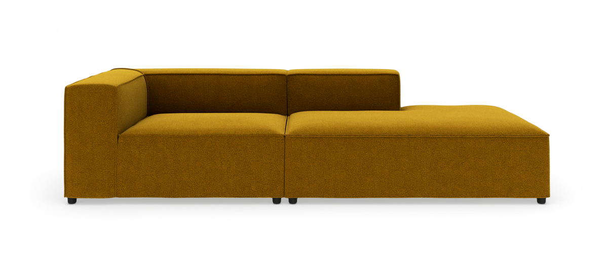 Modulsofa med venstre armlæn og højre chaiselong i sennepsgul tekstil på hvid baggrund.