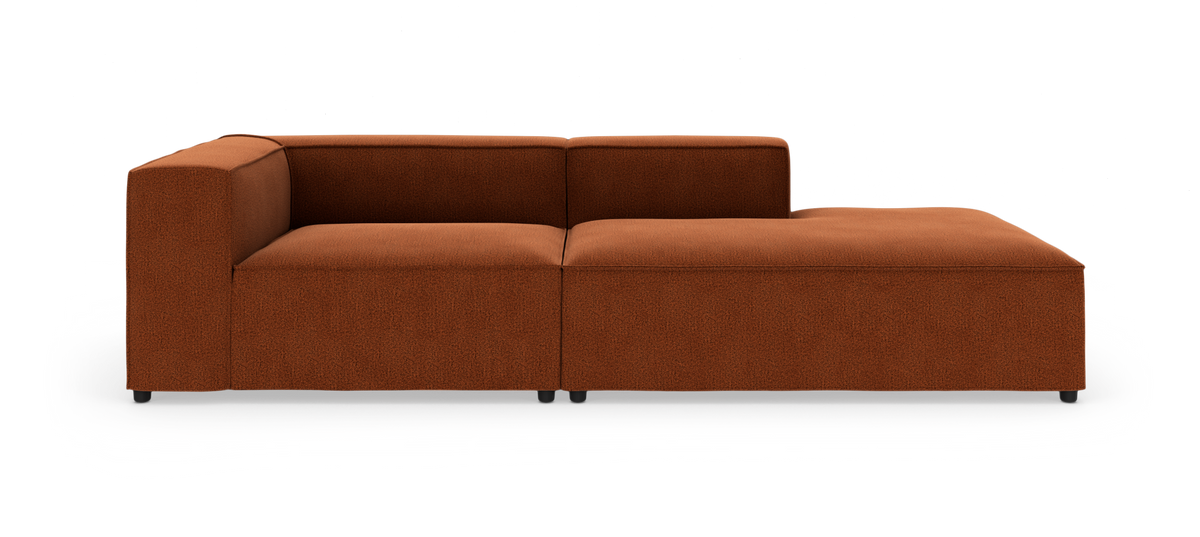 Modulsofa i rustbrunt stof med venstrehjørne og højre chaiselong, fotograferet forfra i studie på hvid baggrund.