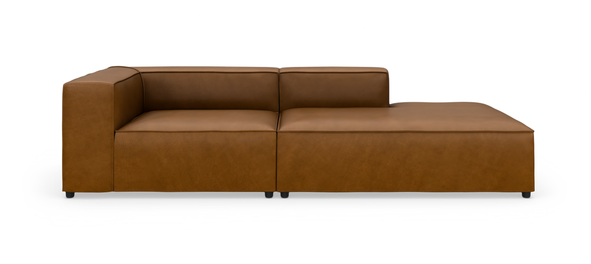 Brun lædersofa med venstrevendt armlæn og højre chaiselong, fotograferet lige for mod hvid baggrund.