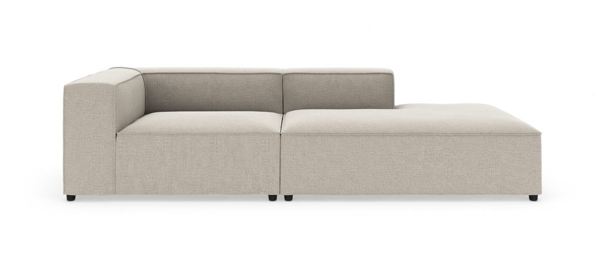 Beige modulsofa med venstrehjørne og højre chaiselong, set forfra på studiobaggrund.