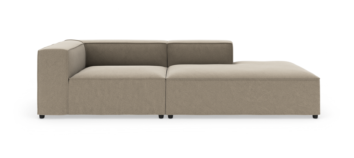 Beige modulsofa med venstre hjørne og højre chaiselong, lav profil på små sorte ben, isoleret på hvid baggrund.