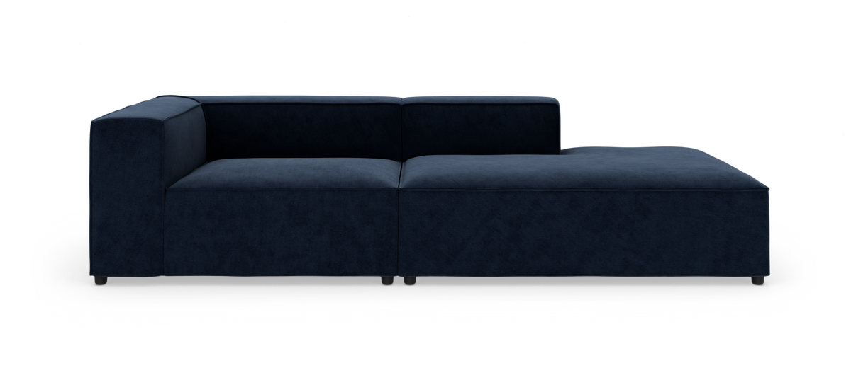 Mørkeblå, moderne modulsofa med højrevendt chaiselong, fotograferet lige forfra mod hvid baggrund.