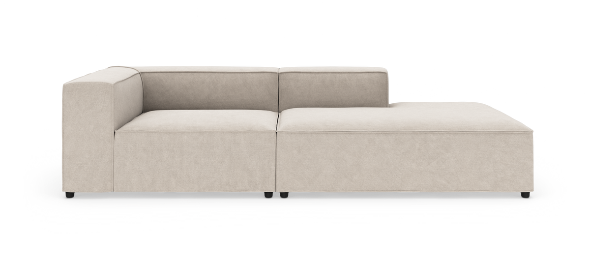 Beige modulsofa med venstre armlæn og højre chaiselong, vist forfra mod hvid baggrund.