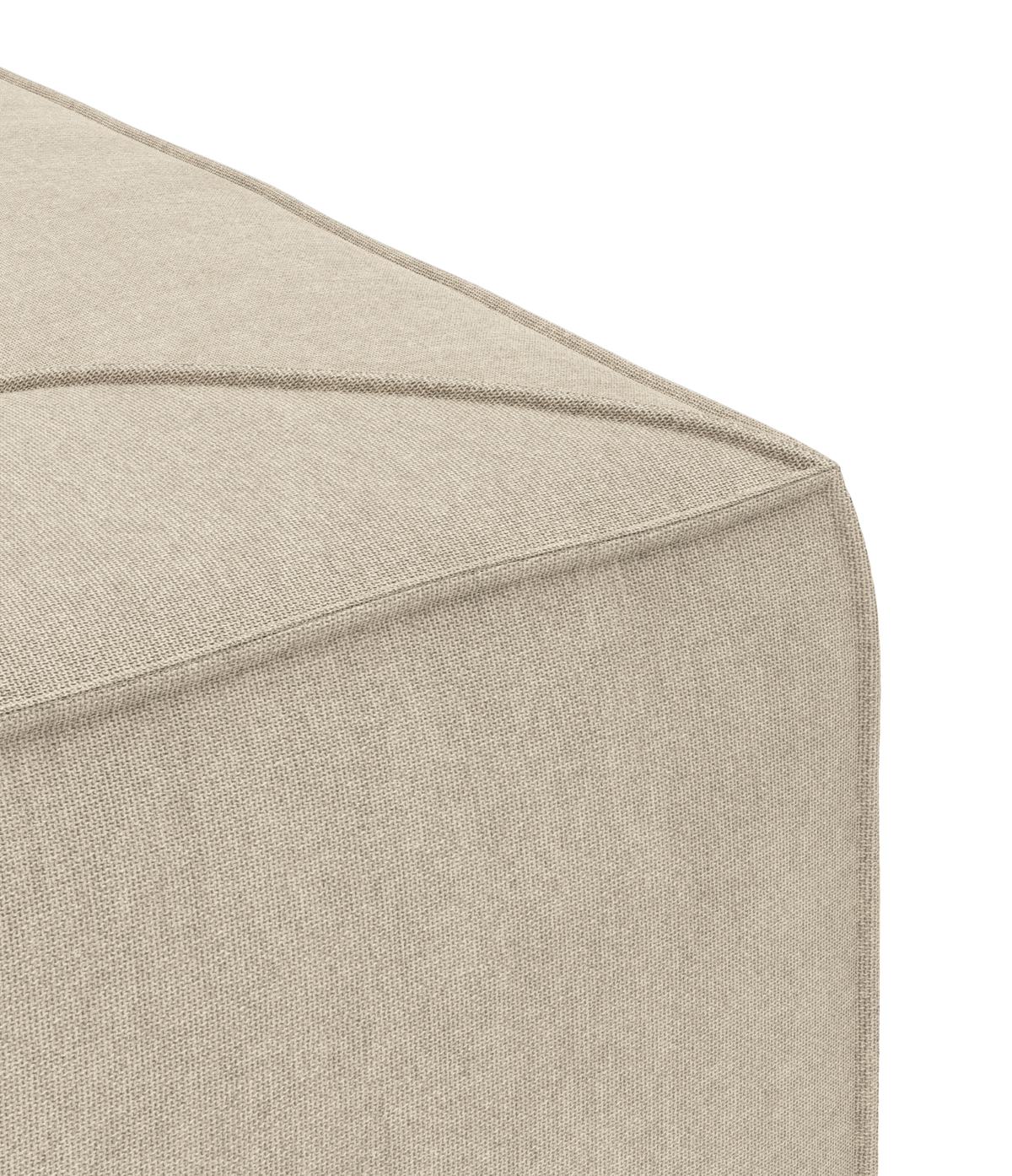 Nærbillede af beige stofpuf med markerede syninger i et studie.