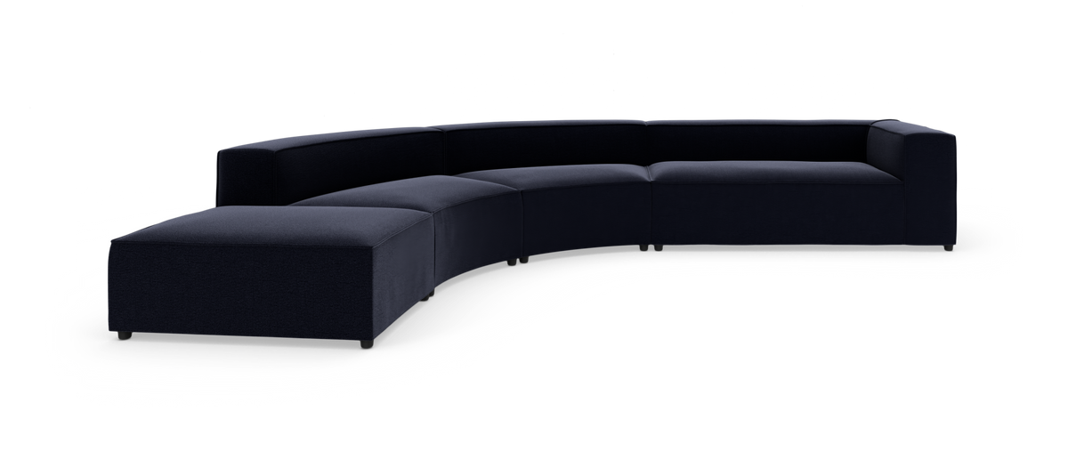 Modulær, mørkeblå, buet sofa i studie mod hvid baggrund.
