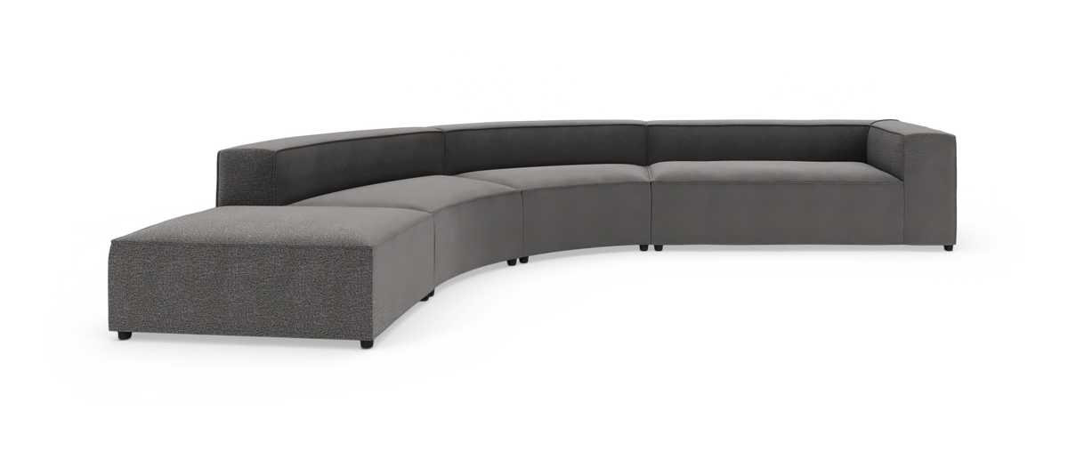 Bueformet modulsofa i gråt tekstil med chaiselong, fritstående på hvid baggrund.