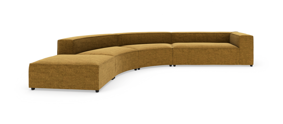 Modulær, buet sofa i sennepsgul tekstil med ottoman‑afslutning til venstre og højre armlæn, frilagt på hvid baggrund.