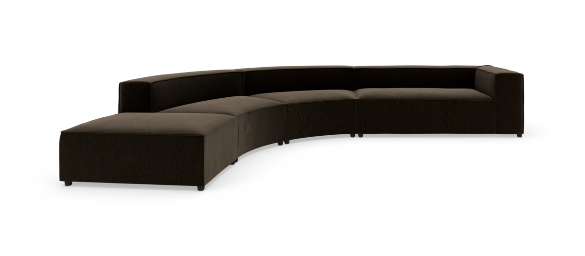Modulsofa i mørkebrun velour med bløde, buede sektioner og bred chaiselong, fritstående på hvid baggrund.