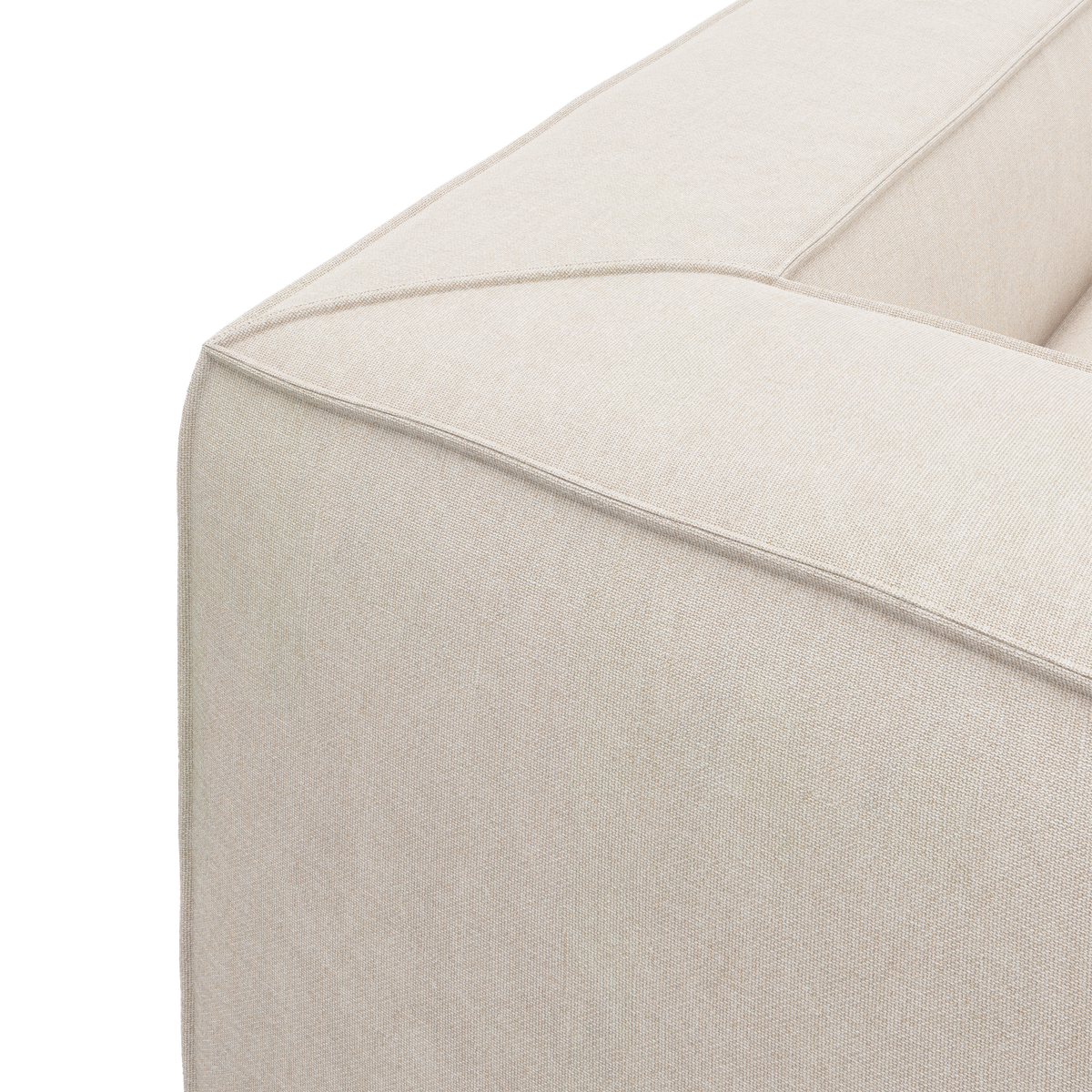 Nærbillede af hjørnet på en beige stofbeklædt modulsofa med markerede syninger.