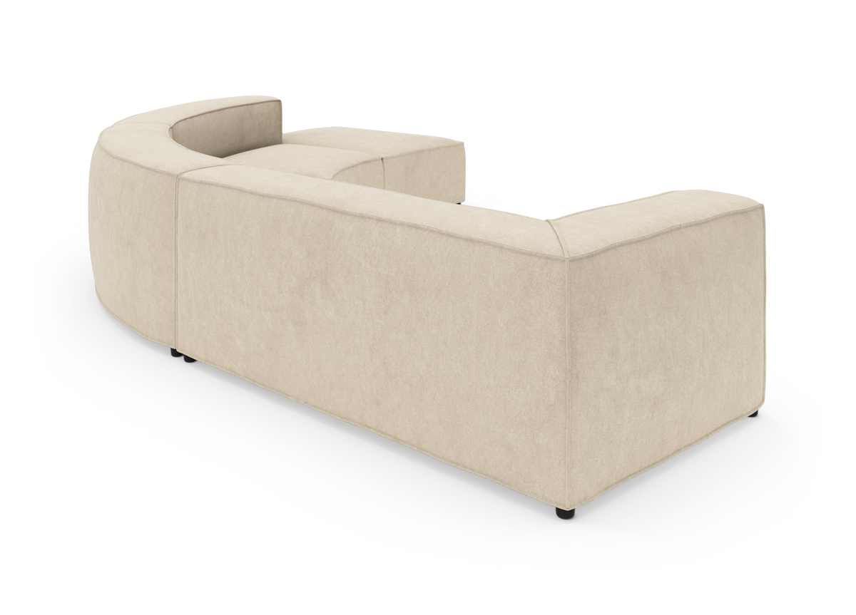 Beige modulsofa i afrundet U‑form set skråt bagfra på hvid studiobaggrund.