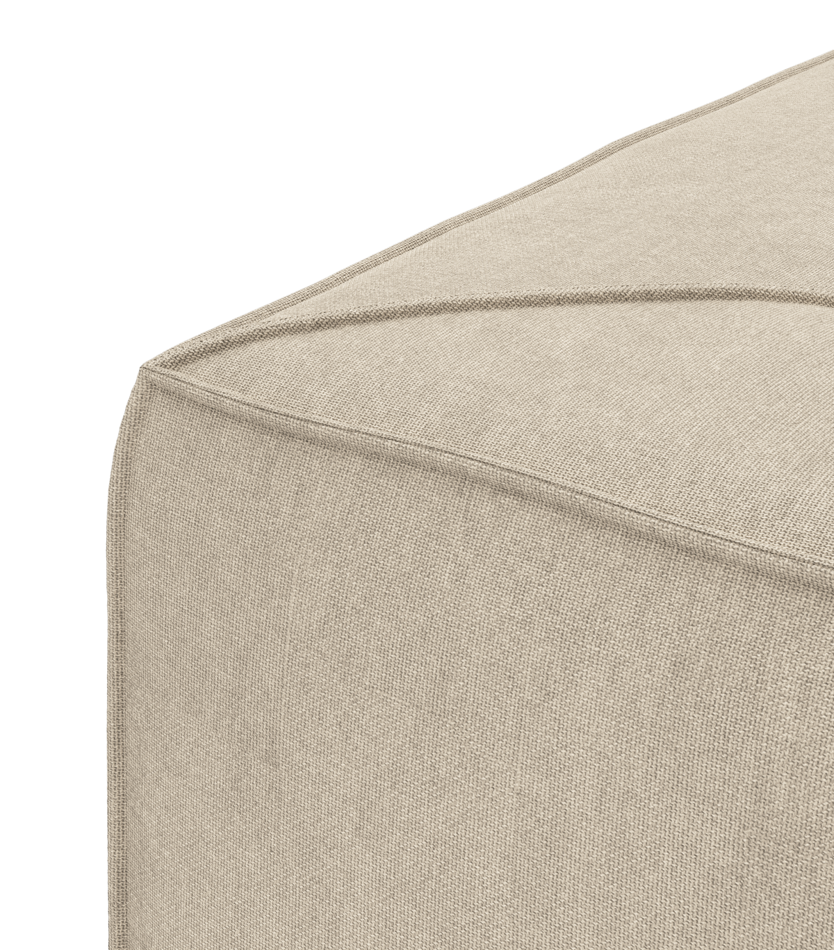 Nærbillede af beige stofpuf med markerede syninger i hjørnet.