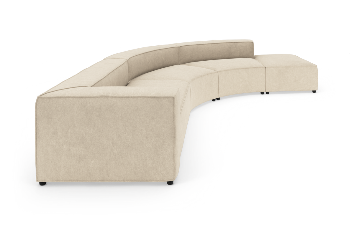 Buet modulsofa i beige stof med lav ryg og kubiske armlæn, frilagt på hvid baggrund.