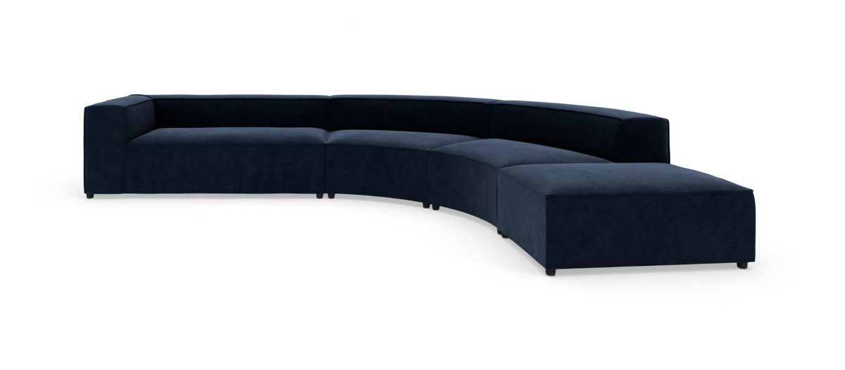 Mørkeblå modulær buet hjørnesofa i velour med lav ryg og brede armlæn, frilagt på hvid baggrund.