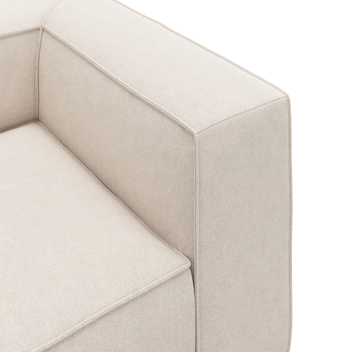 Nærbillede af beige stofsofas hjørne med kantet armlæn og sæde, frilagt mod hvid baggrund.