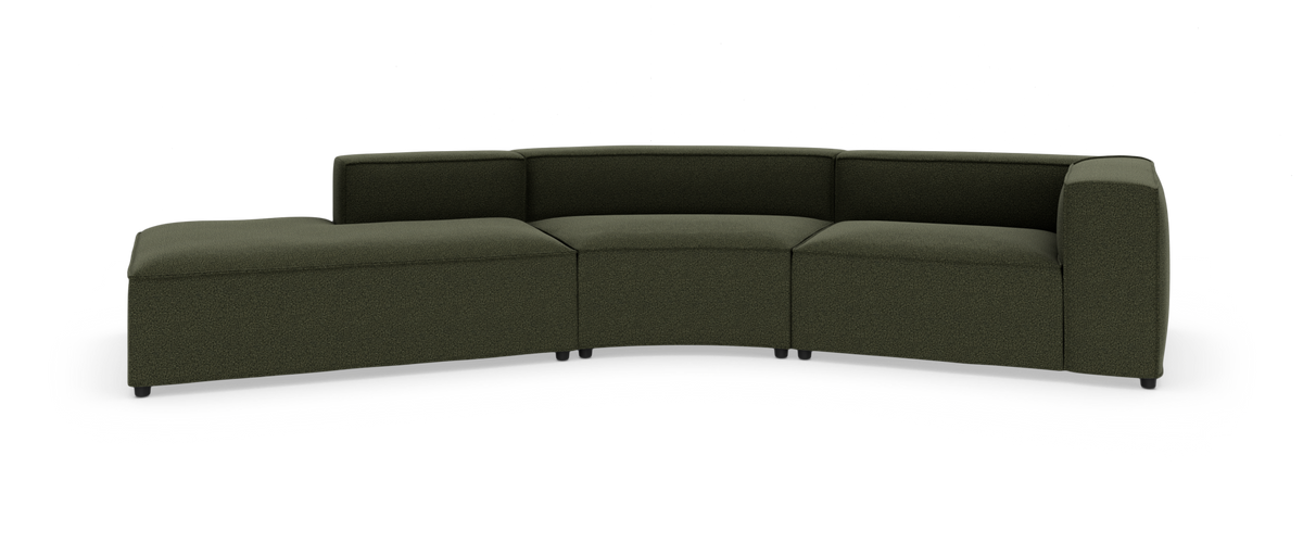 Modulær grøn hjørnesofa i sektioner med chaiselong, fotograferet mod hvid studiobaggrund.