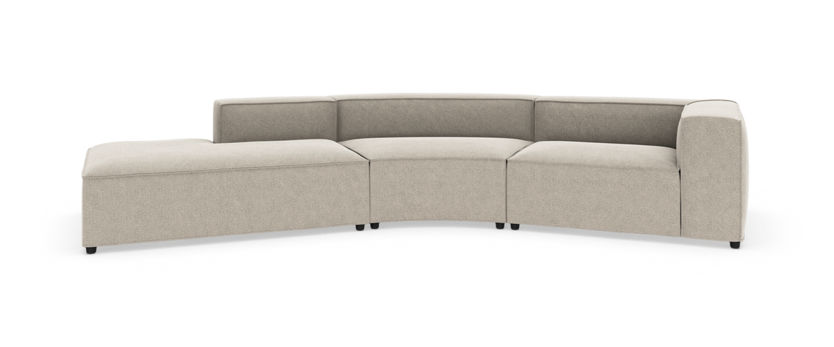 Beige modulsofa i L‑form med buet midtersektion og chaiselong, frilagt på hvid baggrund.