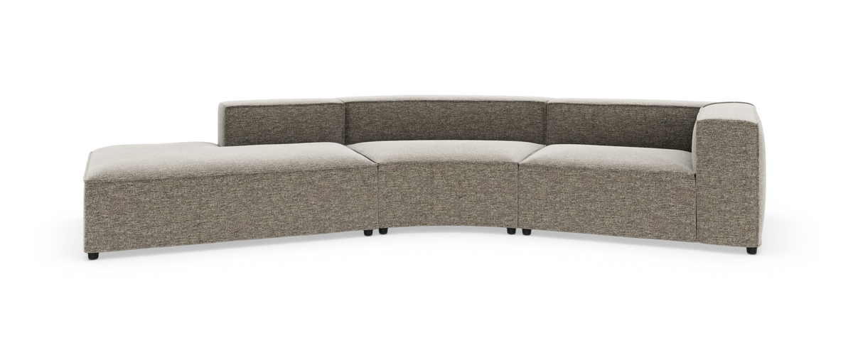 Modulær, buet sofa med venstre chaiselong i grå‑beige stof, fritlagt på hvid baggrund.